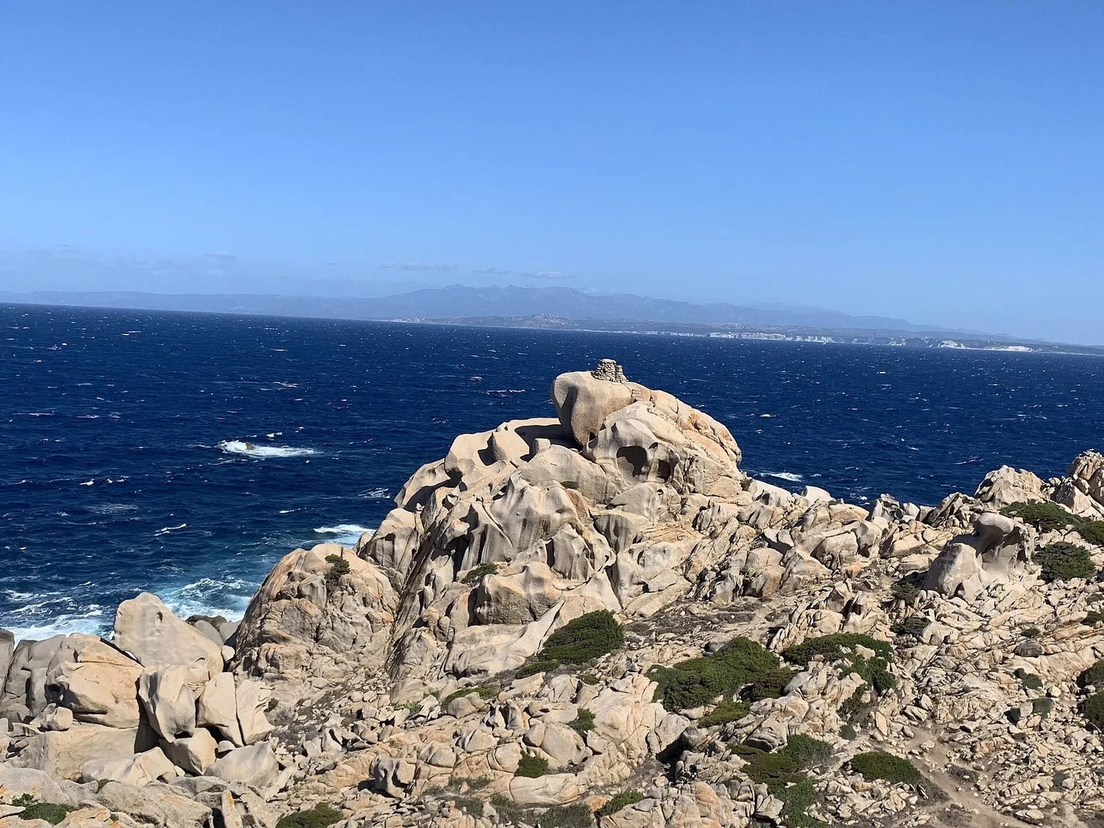 Rocce di granito modellate dal vento a Capo Testa, con il mare delle Bocche di Bonifacio e la costa della Corsica sullo sfondo
